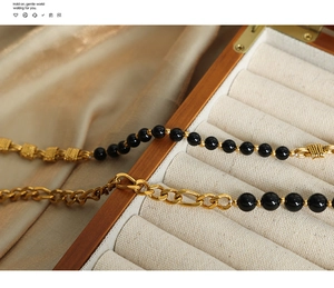 Detail of vintage black agate beaded necklace with gold OT buckle on silk fabric