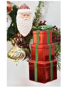 Detail of red gift box stack and Santa ornaments on festive Christmas greenery