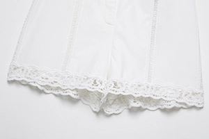 Détail de l'ourlet en dentelle au crochet blanche et rubans verticaux sur le short