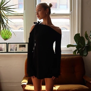 Detalle del vestido negro con hombros descubiertos y elegante lazo en la manga larga