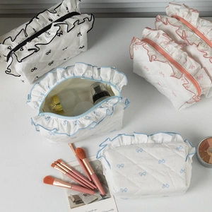 Detailed view of quilted makeup bags with bow prints, ruffles and zipper closure