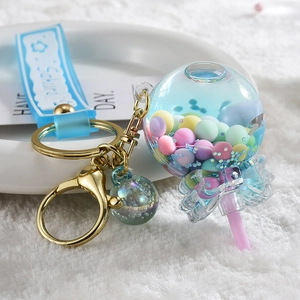 Lolly sleutelhanger met kleurrijke kralen en Sakura-band op witte pluche ondergrond