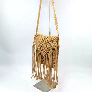 Close-up of bohemian hand-woven shoulder bag with fringe tassels and diamond mesh pattern