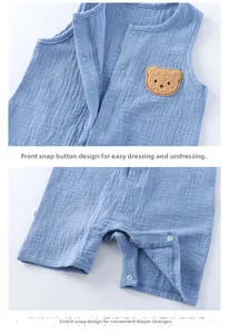 Detail of baby cotton romper featuring resin snap buttons and a 3D teddy bear patch