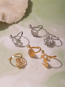 Detailed macro view of octopus, seashell, and seahorse rings with white zircon stones