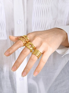 Detailed view of layered 18k gold plated chain rings stacked on female fingers