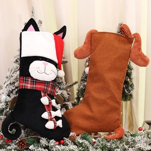 Plush Christmas stockings featuring cartoon cat and dog designs on snowy pine branches