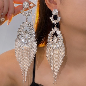 Détails macro des boucles d'oreilles longues argentées avec pampilles en diamant