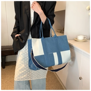 Detail of multi-tone denim patchwork tote bag featuring adjustable crossbody strap