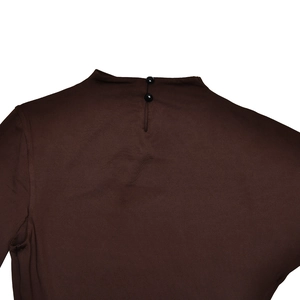 Detail view of high collar with back teardrop opening and black buttons on brown dress