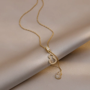 Vue macro du pendentif double gourde avec zircons blancs sur fond de satin champagne
