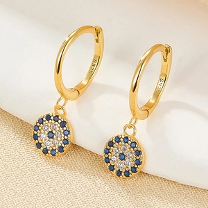 Macro detail of S925 sterling silver stamp on gold evil eye hoop earrings