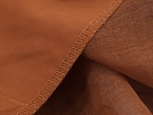 Detail of high-quality stitching and mesh fabric joint on deep brown dress