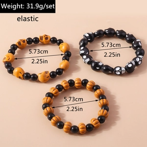 Detailed view of Halloween elastic bracelet set with skull and pumpkin beads and sizing