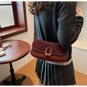 Detail showing high-quality burgundy suede and leather textures with gold metal lock buckle