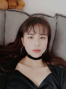 Close-up of minimalist large metal hoop earrings and black velvet choker on female model