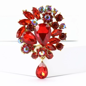 Close-up of luxury red crystal brooch with pear-shaped drops and gold plating