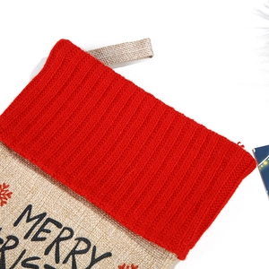 Close-up of red knit cuff and Merry Christmas embroidery on linen Christmas stocking