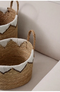 Detail of hand-woven seagrass baskets with white cotton rim and zigzag stitching