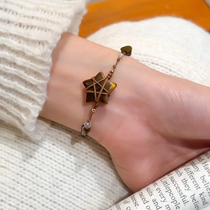 Detailed close-up of handmade tiger eye star bracelet with woven cord and crystal beads