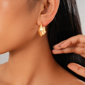 Boucles d'oreilles cœur dorées minimalistes au design géométrique en C sur le mannequin