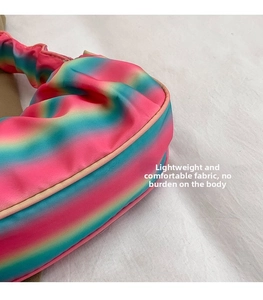 Close-up of rainbow gradient pleated fabric with vibrant pink, blue and green texture