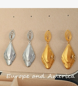 Detail of minimalist teardrop earrings in gold and silver finishes on jewelry lining