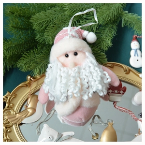 Detail of pink Santa plush ornament with white ribbon on vintage gold mirror surface