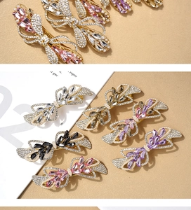 Detailed close-up of crystal bow hair clips with pearls and rhinestones on a magazine