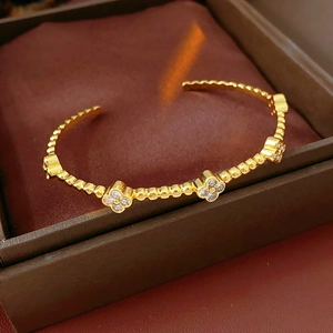 Dettaglio del bracciale a fiori placcato oro con zirconi su velluto marrone scuro