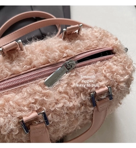 Detail of smooth silver zipper on pink faux wool box bag with soft plush texture