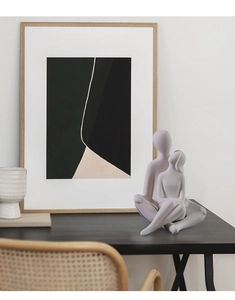 Detail view of modern matte ceramic hug sculpture in a minimalist living room setting