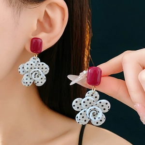 Vue détaillée des clous d'oreilles rouges carrés et boucles d'oreilles fleurs à pois