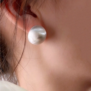 Matte silver ball stud earring on model with minimalist brushed metal finish