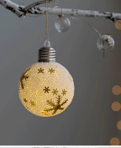 Detail of Christmas snow globe light with golden snowflake patterns and warm LED glow