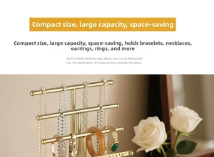 Close-up of golden 4-tier T-bar jewelry stand with earring holes in a warm home setting