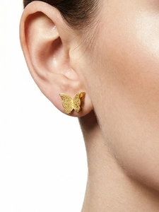 Detailed view of gold butterfly stud earring with textured matte finish on a model