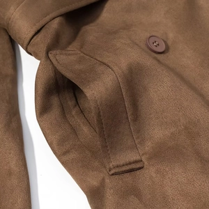 Detailed close-up of brown faux suede fabric and pocket stitching with a matching button