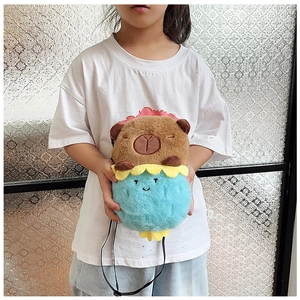 Detail view of a plush Capybara crossbody bag shown with a child model for size reference