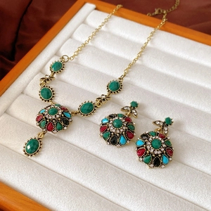 Dettaglio del set collana e orecchini vintage con gemme colorate in portagioie
