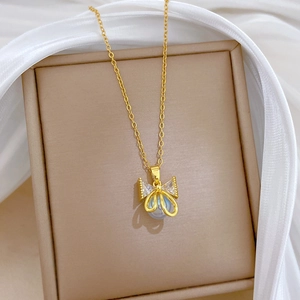 Detailed macro shot of a golden bow pendant with pearls and blue gems in a jewelry box