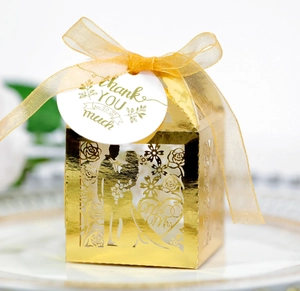 Detail of laser-cut Mr & Mrs wedding candy box in mirror gold with a Thank You tag
