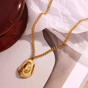 Detail shot of a vintage golden cowboy hat pendant necklace with a polished 18K gold finish