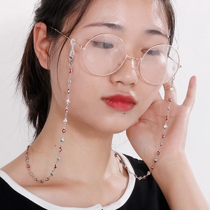 Elegant stainless steel eyeglass chain with red eye beads and heart charms shown on model