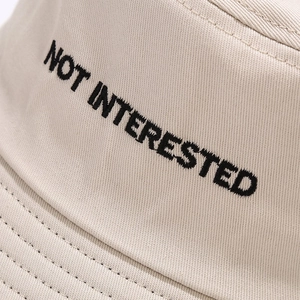 Dettaglio del cappello alla pescatora in tela beige con ricamo nero personalizzato