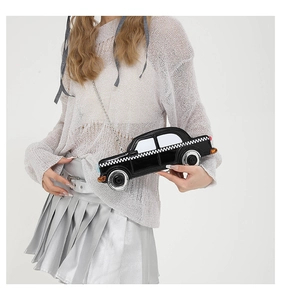 Detail of creative black car shaped crossbody bag with silver chain on model