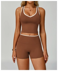 Dettaglio del set da yoga marrone con bordi bianchi a contrasto su top sportivo e pantaloncini