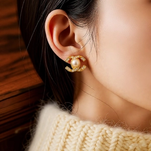 Detail of 14k gold plated flower stud earrings with pearls and crystals on a model