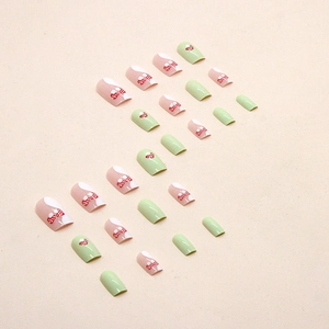 Green and white mixed press-on nails with red polka dot bow designs in square-oval shape