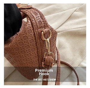 Close-up of brown woven leather bag with star pattern texture and gold metal clasp